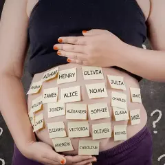 Pancia di donna incinta con post-it con nomi, tra cui alcuni nomi femminili particolari come Olivia e Julia, circondata da punti interrogativi.