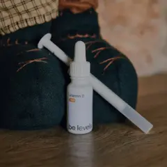 Flacone di vitamina D per neonati con contagocce, accanto a un pupazzo.