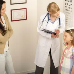 Medico misura altezza bambina, madre osserva. Valutazione del rapporto altezza peso per la crescita.