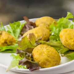 Deliziose polpette di pesce per bambini, servite su un letto di insalata fresca.