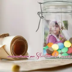A rolled scroll tied with twine and a glass jar filled with colorful candies and a child's photo.
