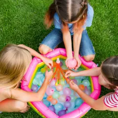 Bambine si divertono con palloncini d'acqua, perfetti giochi per feste di compleanno 7-8 anni.