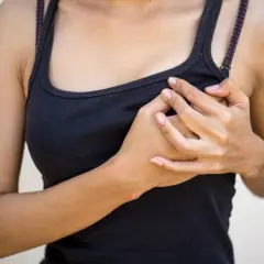 Mani che stringono il seno gonfio senza ciclo, un disagio che preoccupa.