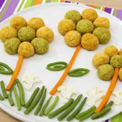 Fiori colorati fatti con ceci e patate, con gambi di carota e foglie di fagiolini.