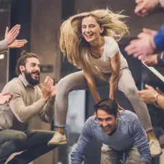 Un gruppo di amici si diverte con giochi da fare in gruppo seduti senza niente, tra risate e applausi.