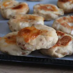 Deliziose polpette di pollo appena sfornate, dorate e con formaggio filante, pronte per essere gustate.