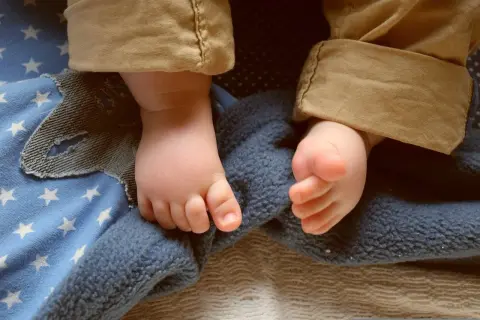 Piedini di bimbo su coperta stellata, pronti per dolci storie per bambini per dormire.