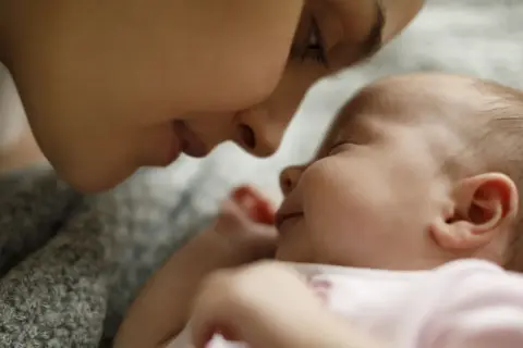 Dolce momento tra madre e neonato, immersi in un'atmosfera di pace, quasi come i rumori bianchi neonato che cullano il sonno.