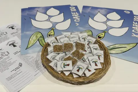 Cesto con semi per lavoretti quaresima per bambini catechismo. Volantini con disegni e frasi sul seguire le orme di Gesù.