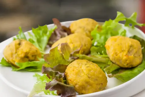 Deliziose polpette di pesce per bambini, servite su un letto di insalata fresca.