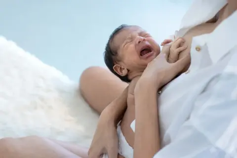 Bambino piange disperato, ma la mamma lo consola. Se non mangia la pappa gli do il latte.
