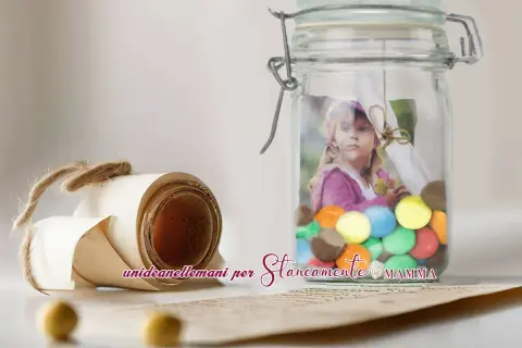 A rolled scroll tied with twine and a glass jar filled with colorful candies and a child's photo.