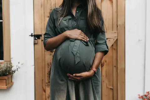 Donna incinta accarezza il pancione, un momento di attesa e speranza per chi desidera come rimanere incinta.