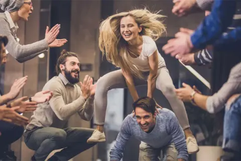Un gruppo di amici si diverte con giochi da fare in gruppo seduti senza niente, tra risate e applausi.