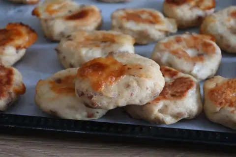 Deliziose polpette di pollo appena sfornate, dorate e con formaggio filante, pronte per essere gustate.