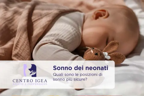 Un neonato dorme sereno con un coniglietto di pezza. Scopri quanto dormono i neonati e le posizioni più sicure per il loro riposo.