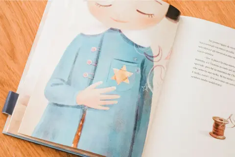 Illustrazione per il giorno della memoria spiegato ai bambini: una bambina con una stella gialla cucita sul cappotto.