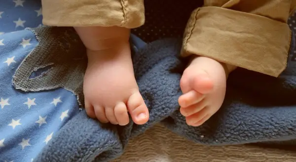 Piedini di bimbo su coperta stellata, pronti per dolci storie per bambini per dormire.