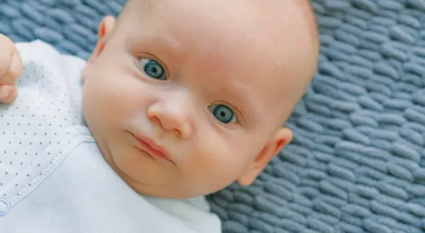 Occhi di un neonato di un blu intenso, quasi neon, che catturano lo sguardo.
