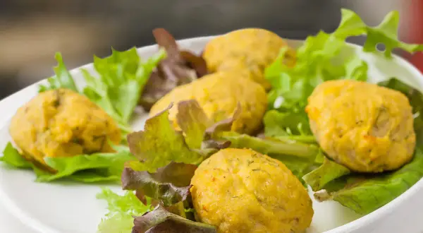 Deliziose polpette di pesce per bambini, servite su un letto di insalata fresca.