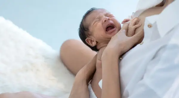 Bambino piange disperato, ma la mamma lo consola. Se non mangia la pappa gli do il latte.