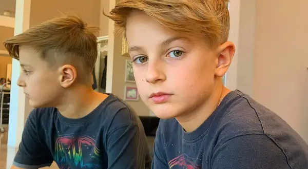Ragazzo con un taglio lungo e sbarazzino, riflesso nello specchio.