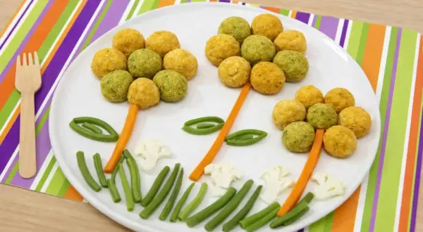 Fiori colorati fatti con ceci e patate, con gambi di carota e foglie di fagiolini.
