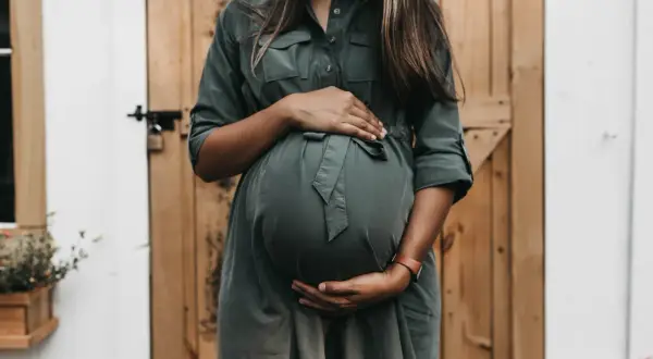 Donna incinta accarezza il pancione, un momento di attesa e speranza per chi desidera come rimanere incinta.