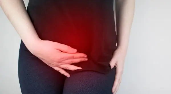 Donna con le mani sull'addome, evidenziato da un bagliore rosso, che indica dolori ovulazione da 5 giorni.