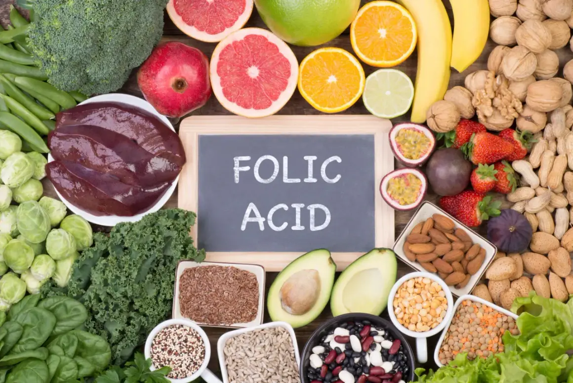 La **folina a cosa serve**? È essenziale per la crescita cellulare. L'immagine mostra alimenti ricchi di folati: verdure a foglia verde, fegato, agrumi, legumi e frutta secca.