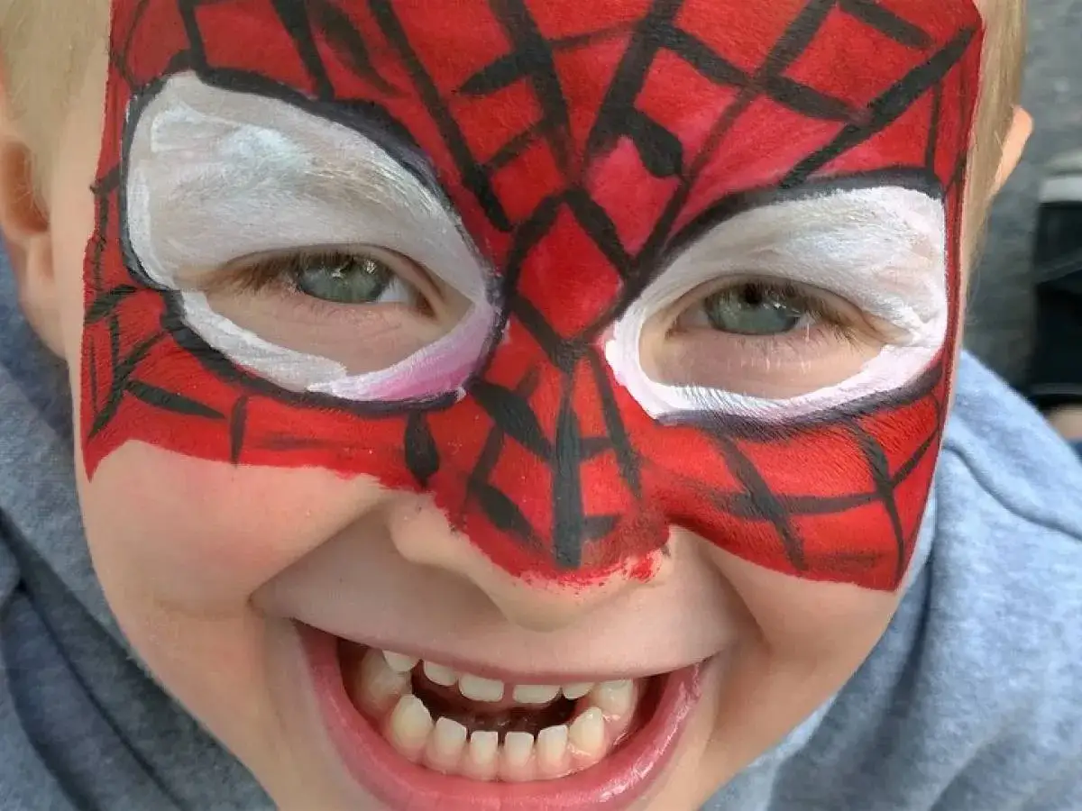 Bambino felice con trucco carnevale facile da Spider-Man sul viso.