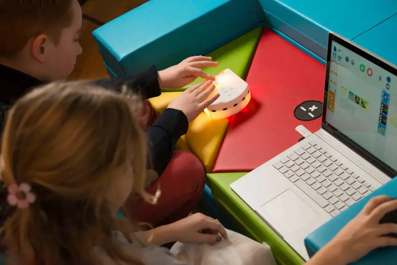 Bambini imparano il coding con un robot interattivo e un laptop.