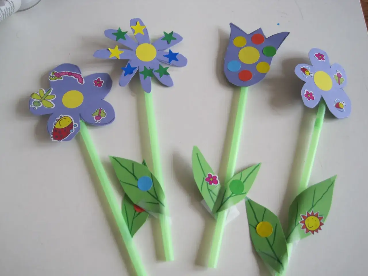 Fiori di carta colorati, perfetti per la festa della mamma in Italia. Farfalle, coccinelle e stelle decorano questi allegri lavoretti.