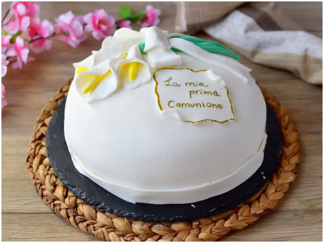 Semplice torta prima comunione decorata con calle bianche e un cartiglio dorato.