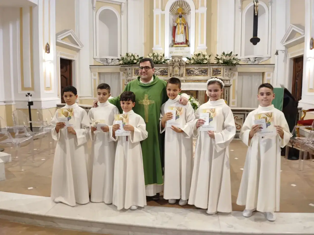 Bambini festeggiano la Prima Comunione, un rito che solitamente si fa verso i 7-8 anni.