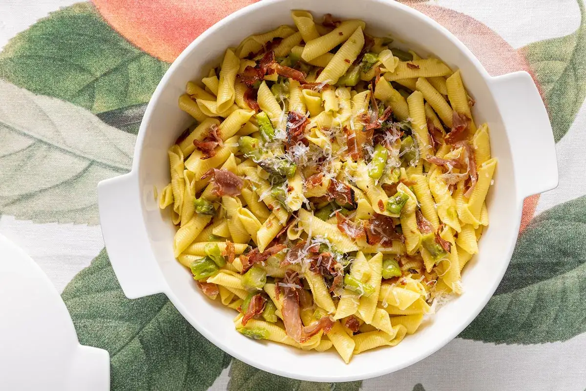 Piatto di pasta per bambini con piselli, pancetta croccante e parmigiano. Un primo piatto gustoso e colorato.