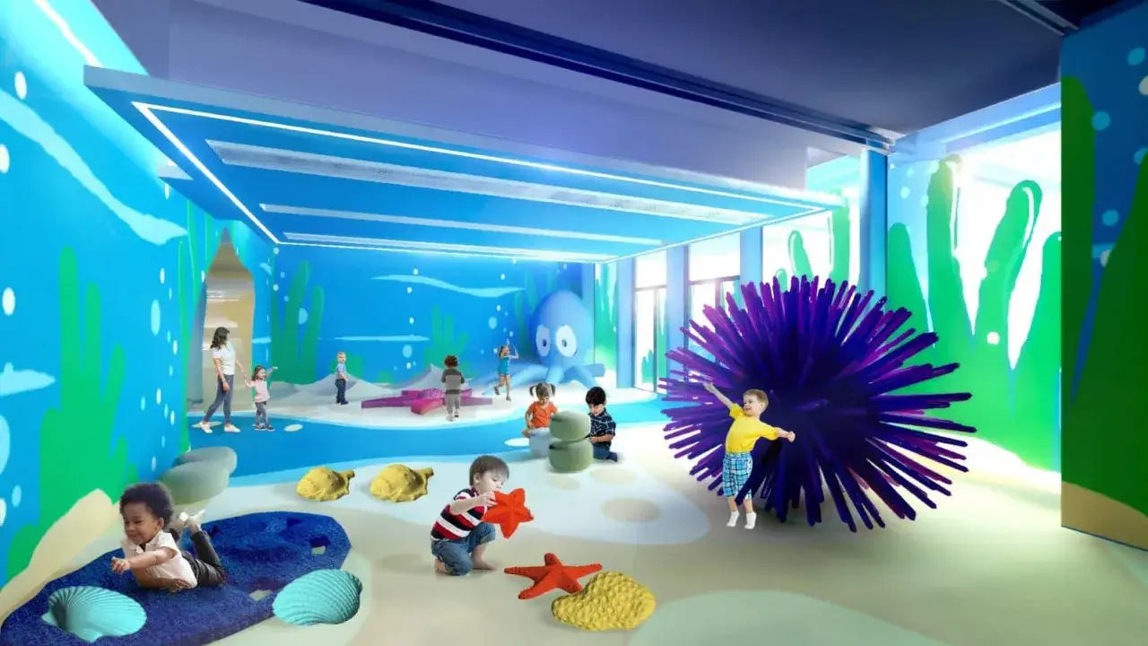 Bambini giocano in un ambiente sottomarino colorato, un esempio di musei per bambini con un grande polpo e giochi interattivi.