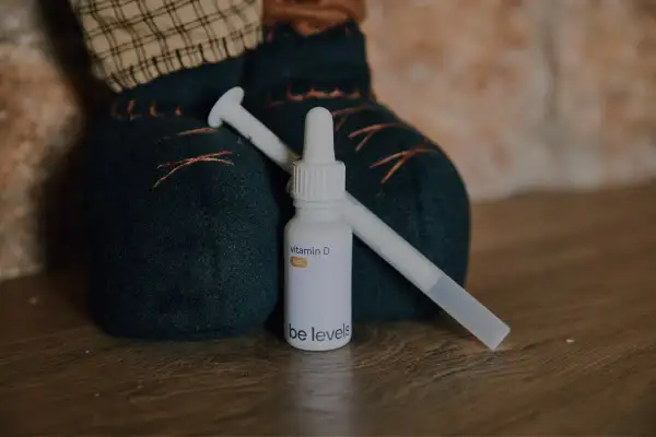 Flacone di vitamina D per neonati con contagocce, accanto a un pupazzo.