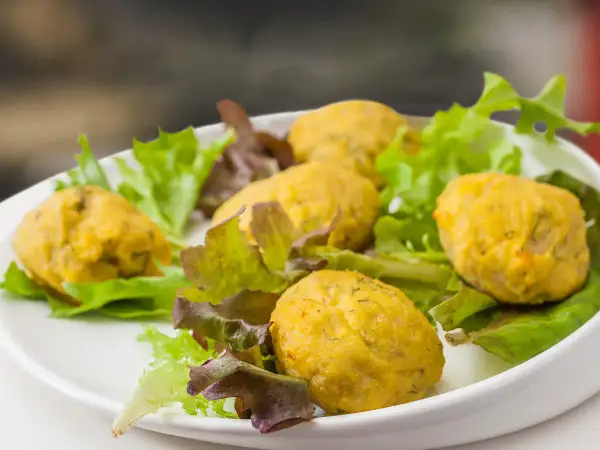 Deliziose polpette di pesce per bambini, servite su un letto di insalata fresca.