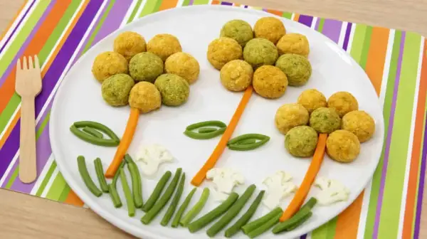 Fiori colorati fatti con ceci e patate, con gambi di carota e foglie di fagiolini.