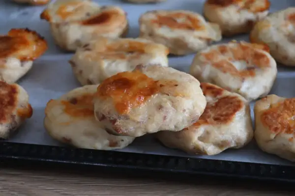 Deliziose polpette di pollo appena sfornate, dorate e con formaggio filante, pronte per essere gustate.
