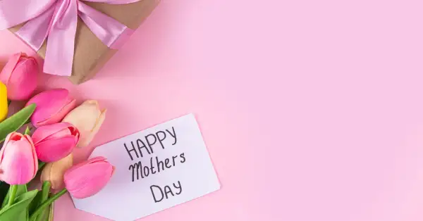 Un regalo incartato con un fiocco rosa e tulipani colorati, pronti per la festa della mamma in Italia.
